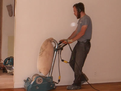 Michael Stalkfleet refinishing a red oak hardwood floor, using a K&T Scorpion sander in Coralville