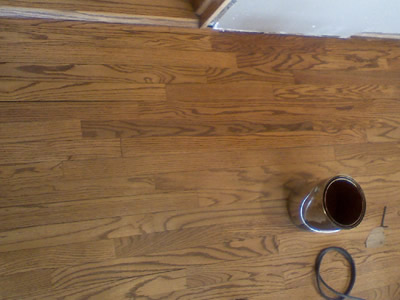 Patched in red oak where a wall used to be, sanded, stained, and finished