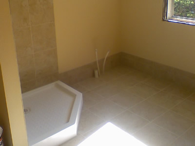 Tile floor, baseboard, and shower stall